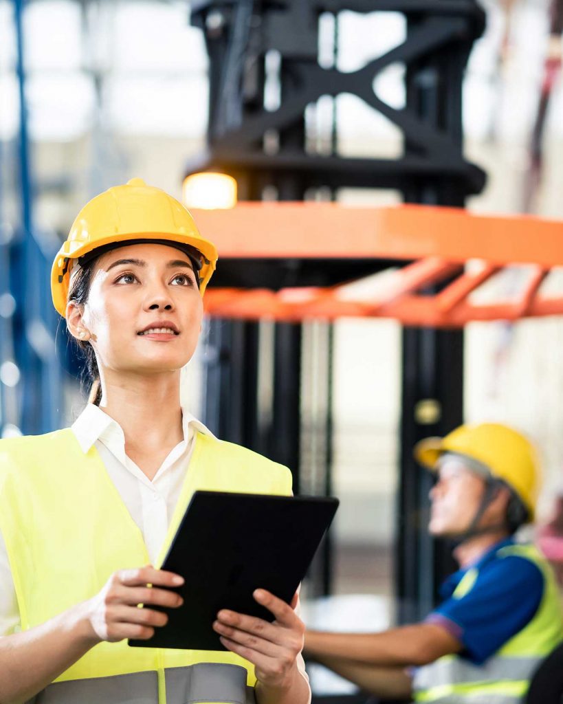 Woman inspecting forklifts