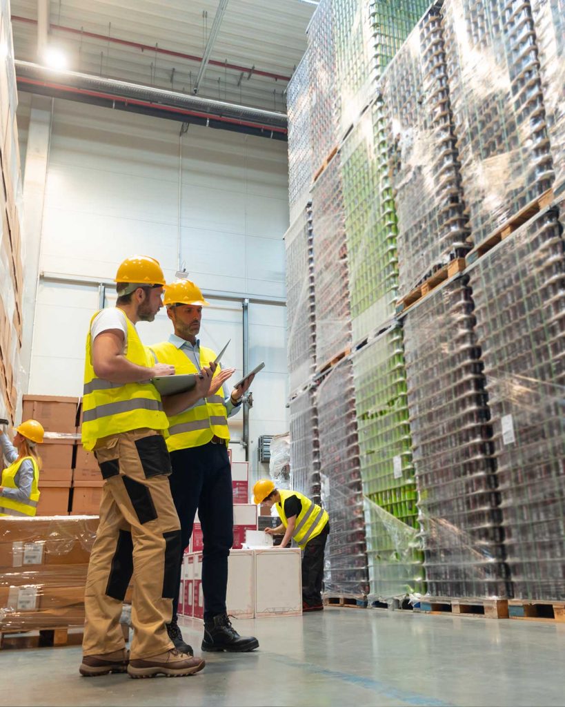 Two forklift operators discussing in warehouse